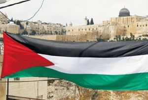 The Al-Aqsa mosque forms the backdrop to a Palestinian flag.